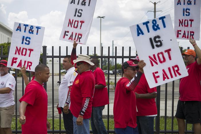 Union workers picket near the entrance to an AT&T facility in Miami, Fla. CWA members on on strike after union negotiators alleged that AT&T management engaged in unfair labor practices during contract negotiations.