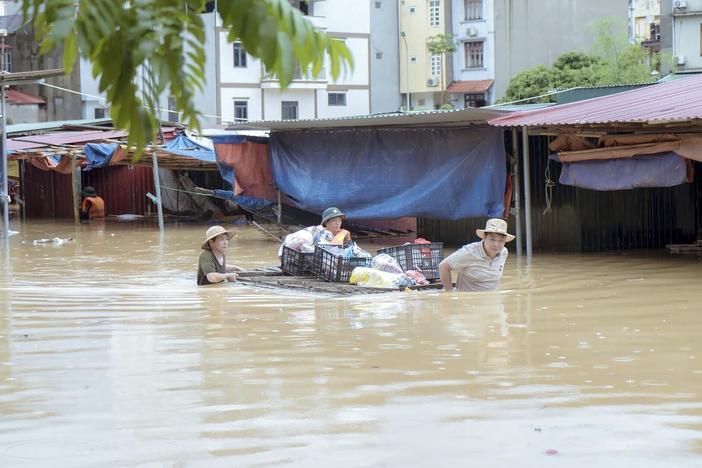 People carry belongings in flood triggered by Typhoon Yagi in Lang Son province, Vietnam, on Monday, Sept. 9, 2024.