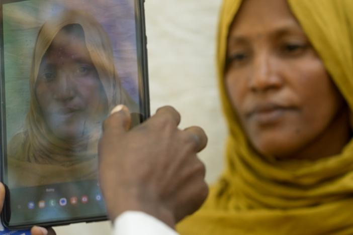 <em>Fatouma Zahara Hasan, a widow with a large family from the town of Chifera, has her photograph taken on a tablet as part of a vast registration drive to ensure that food aid funded by the United States in parts of Ethiopia is only provided to recipients that qualify.  </em>