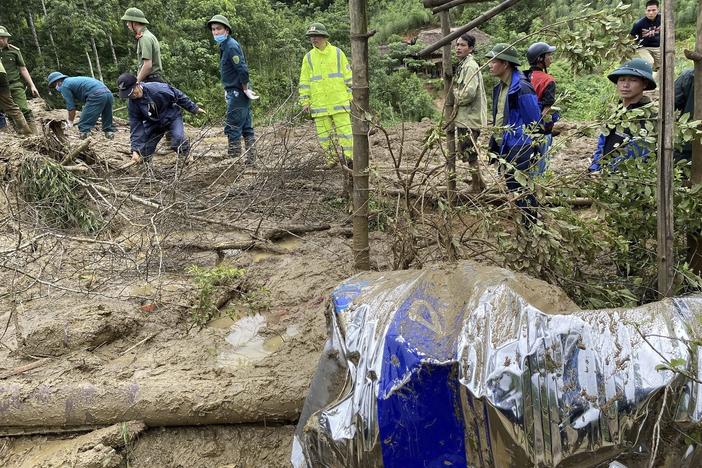 Rescue workers clear mud and debris brought down by a flood in Lang Nu hamlet in Vietnam's Lao Cai province on Tuesday.