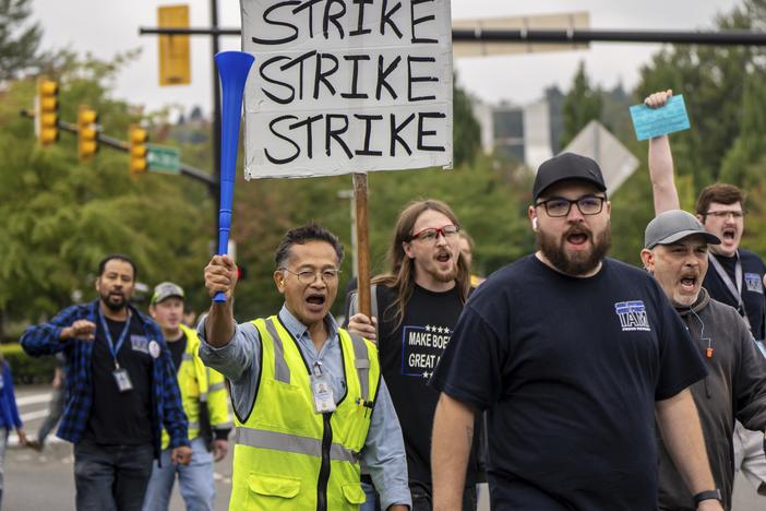 Members of the International Aerospace Machinists union march toward the union's hall Thursday to vote on a contract offer with airplane maker Boeing in Renton, Wash. Workers overwhelmingly rejected the contract and 96% voted to authorize a strike.