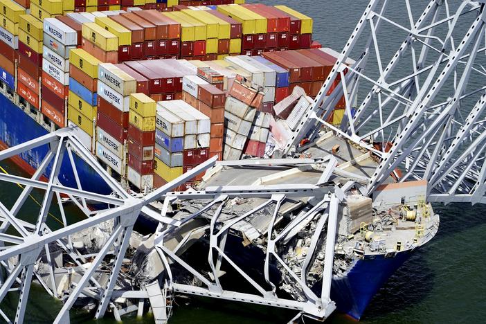 In this aerial image released by the Maryland National Guard, the cargo ship Dali is stuck under part of the structure of the Francis Scott Key Bridge after the ship hit the bridge, March 26, 2024, in Baltimore. 