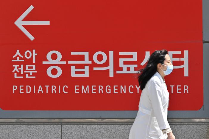 A medical worker walks past a sign for a pediatric emergency center outside a hospital in Seoul on April 1.