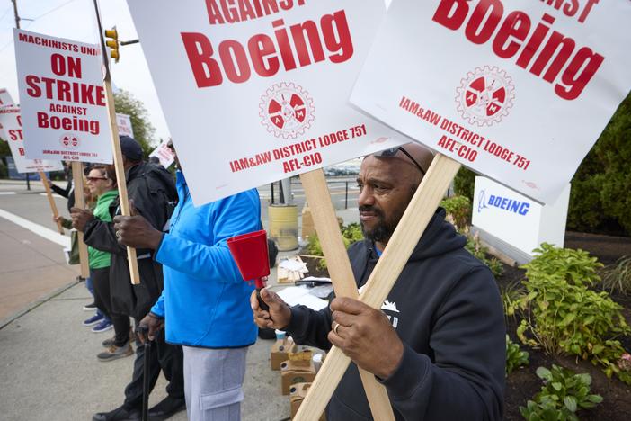 Boeing workers hold signs on the picket line at the Renton assembly plant on Friday in Renton, Wash.
