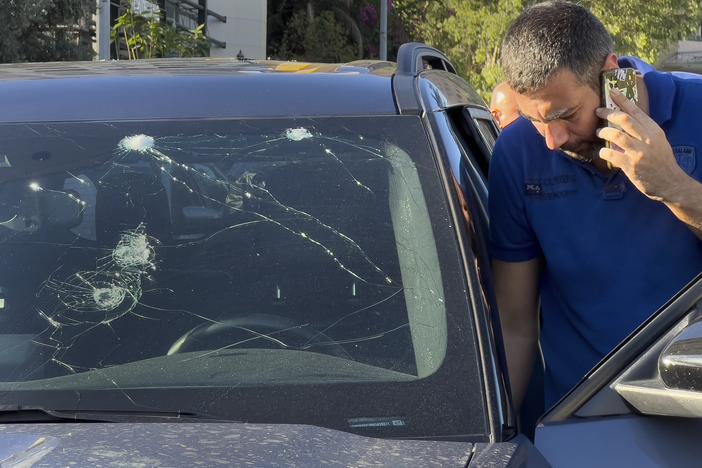 A Lebanese police officer inspects a car damaged by an exploding pager in Beirut on Tuesday. Hundreds of pagers belonging to Hezbollah members exploded simultaneously. The group blamed Israel. 