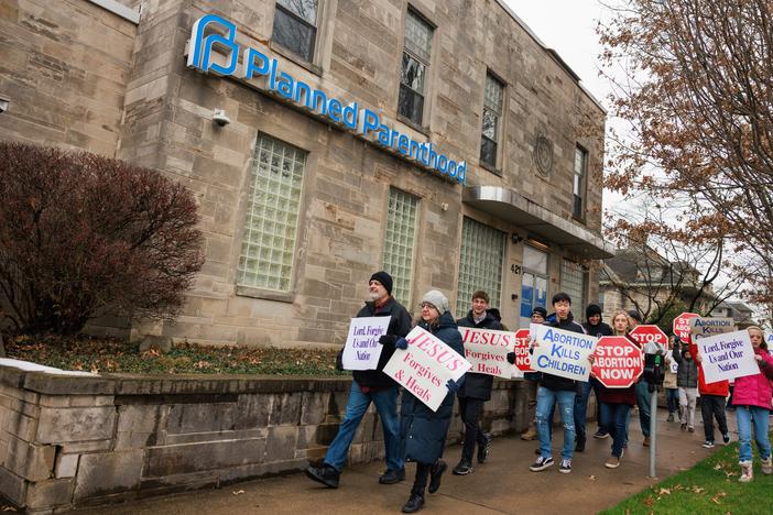 Anti-abortion protesters march past the Planned Parenthood in Bloomington, Ind., after the Rally for Life march in January 2023. The facility offers birth control and testing for sexually transmitted diseases now that abortion is banned in Indiana.