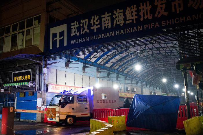 A vehicle belonging to the Wuhan Hygiene Emergency Response Team drives past the shuttered Huanan Seafood Wholesale Market in Wuhan, China, on Jan. 11, 2020 — the day that the Wuhan health commission reported what is believed to be the first death from COVID-19. A new study points to raccoon dogs sold in the market as the likely source of the spillover of the SARS-CoV-2 virus from animals to humans.