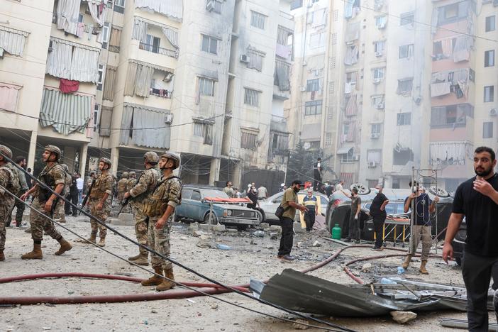 People and members of the military inspect the site of an Israeli strike in the southern suburbs of Beirut, Lebanon, on Friday.