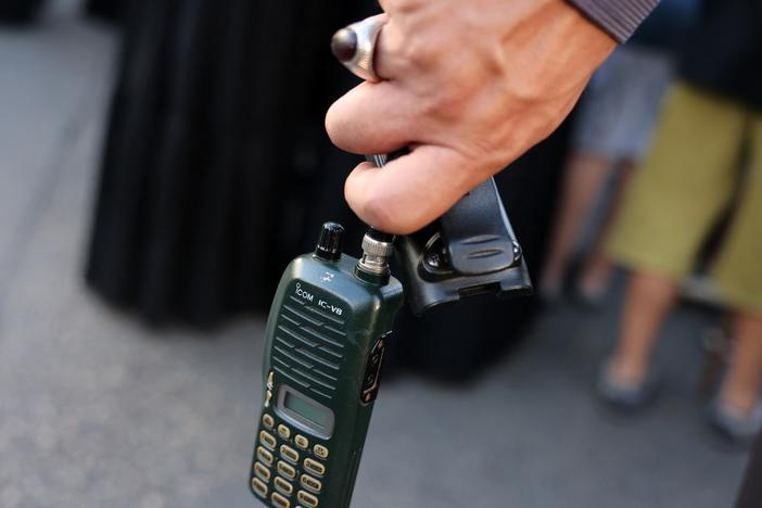 A man holds an Icom walkie-talkie after he removed the battery during a funeral of people killed when hundreds of paging devices exploded in a deadly wave across Lebanon the previous day, in Beirut's southern suburbs on Sept. 18.