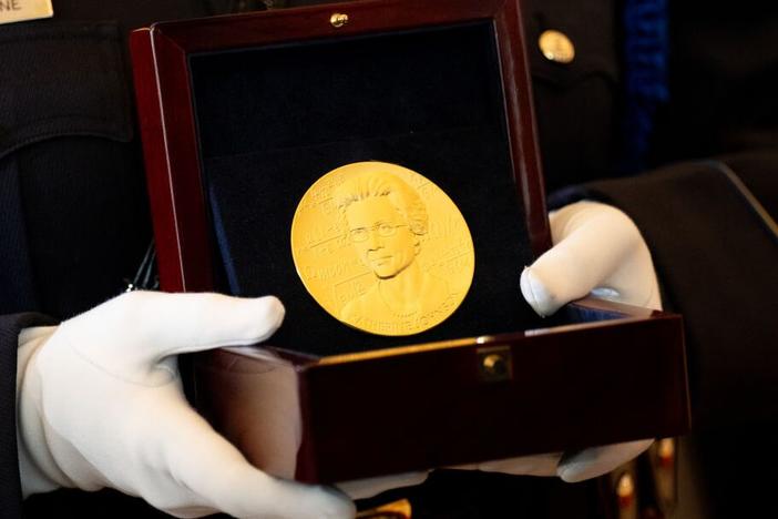 A member of the U.S. Capitol Police carries a Congressional Gold Medal for Katherine Johnson, one of NASA's "Hidden Figures," during a ceremony on Capitol Hill on Wednesday.