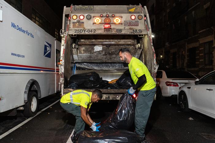  Sanitation workers collect trash in Harlem. 