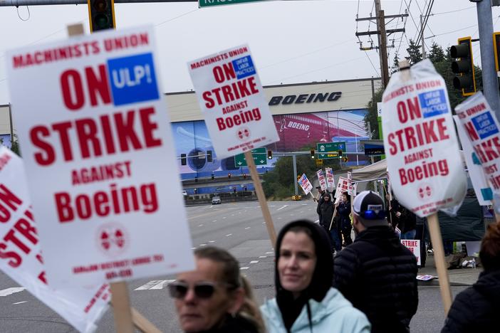 Boeing workers wave picket signs as they strike after union members voted to reject a contract offer, Sunday, Sept. 15, 2024, near the company's factory in Everett, Wash.