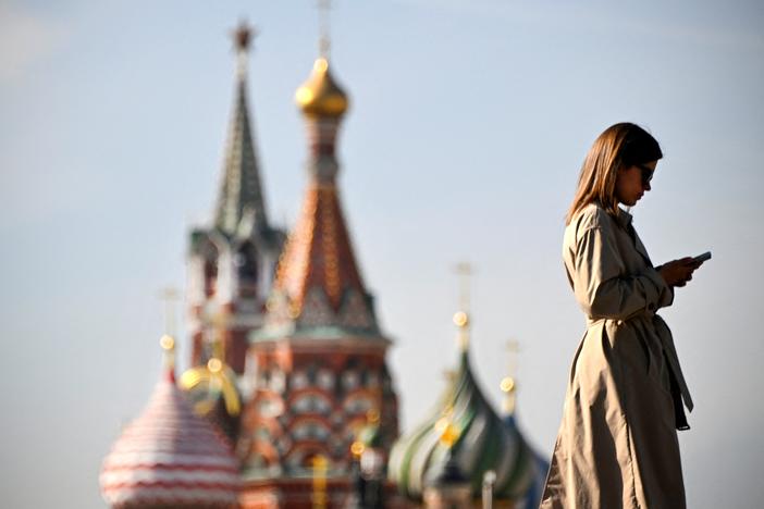 A woman walks in front of the Kremlin on September 23, 2024. U.S. intelligence officials say Russia has embraced artificial intelligence tools to try to sway American voters ahead of the November election. 