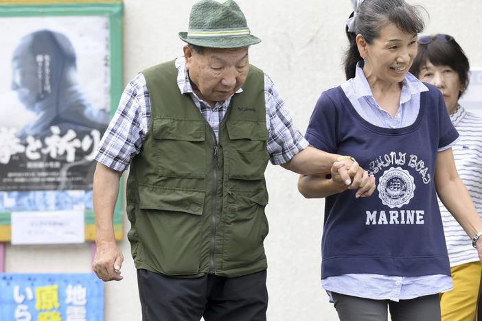 Iwao Hakamada, left, is helped by a supporter as he goes for a walk in Hamamatsu, Shizuoka prefecture, central Japan on Wednesday.
