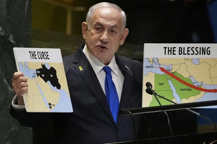 Prime Minister of Israel Benjamin Netanyahu hold signs as he addresses the 79th session of the United Nations General Assembly on Friday.