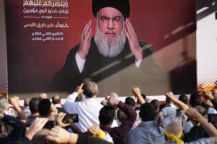 Supporters of the Iranian-backed Hezbollah group raise their fists and cheer as Hezbollah leader Hassan Nasrallah appears via a video link, during a Nov. 3, 2023, rally in Beirut to commemorate Hezbollah fighters who were killed in South Lebanon while fighting against the Israeli forces.
