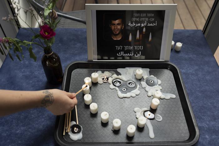 At an LGBTQ+ shelter in Tel Aviv, Israel, on Oct. 7, 2022, a volunteer lights a candle during a vigil for Ahmad Abu Markhiya, a 24-year-old Palestinian man who was found decapitated in the West Bank city of Hebron.