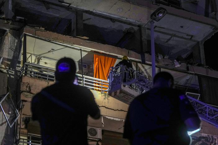 A fire engine ladder extends up a building that was hit in an apparent Israeli airstrike, in central Beirut early Monday, Sept. 30, 2024. 