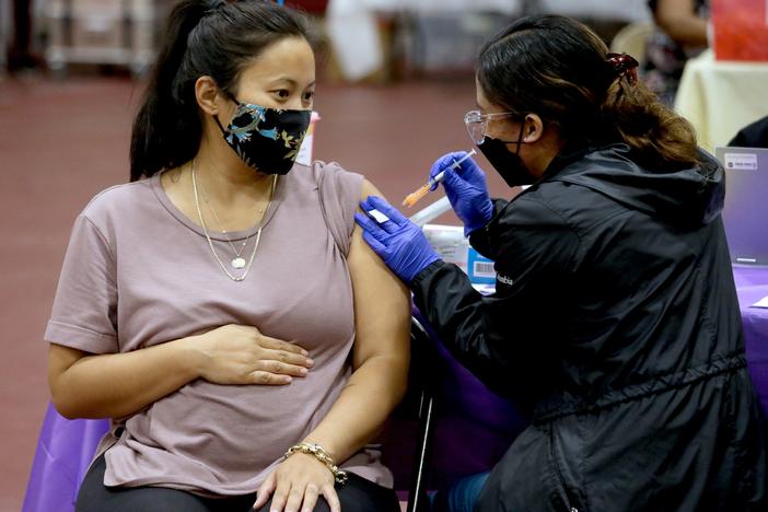 Nicole Fahey, six months pregnant, receives a Pfizer vaccination from a nurse on Nov. 3, 2021 in Los Angeles, CA.