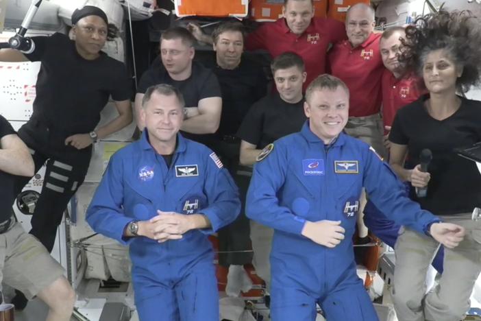 Butch Wilmore, far left, and Suni Williams, far right, welcome Nick Hague, front left in blue, and Alexander Gorbunov, front right in blue, on Sunday. Behind them, from left in black, are NASA's Jeanette Epps, Russia's Alexander Grebenkin, NASA's Mike Barratt and NASA's Matthew Dominick. From left, in red, are Russia's Ivan Vagner, NASA's Don Pettit and Russia's Alexei Ovchinin.