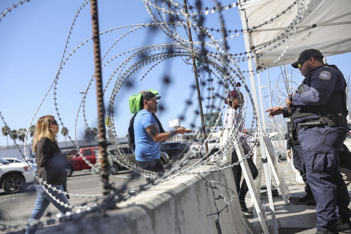 A U.S. Customs and Border Protection agent checks pedestrians' documentation at the San Ysidro Port of Entry in San Ysidro, California. A growing number of experts believe the flow of deadly street fentanyl from Mexico into the U.S. has been disrupted, contributing to a drop in fatal overdoses.