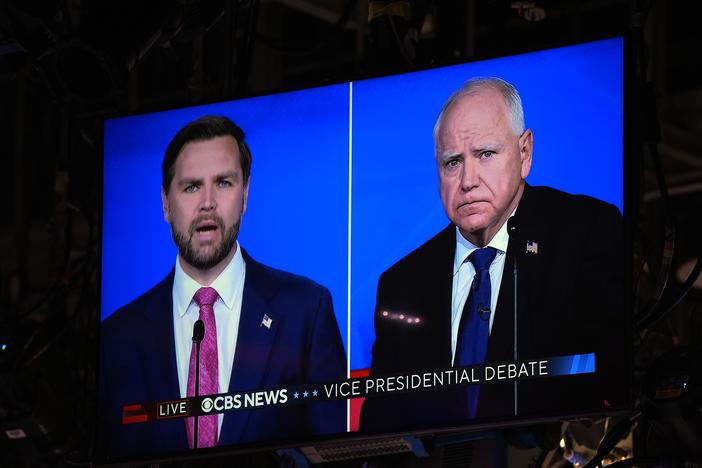 As seen on a monitor in the studio, JD Vance and Tim Walz take part in the vice presidential debate.