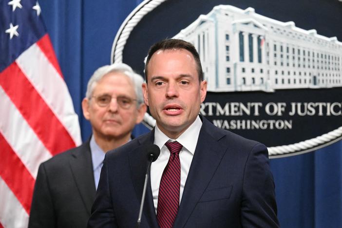 Benjamin Mizer, with Attorney General Merrick Garland (left), speaks during a press conference announcing an antitrust lawsuit against Apple in March 2024.