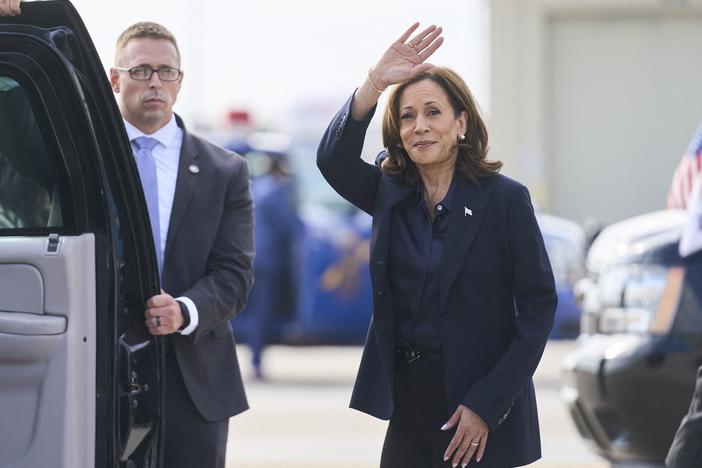 Vice President Harris waves after landing in Flint, Mich., on Oct. 4.