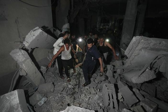 Palestinians carry the body of a person who was found under the rubble of a destroyed mosque following an Israeli airstrike in Deir al-Balah, on Sunday.