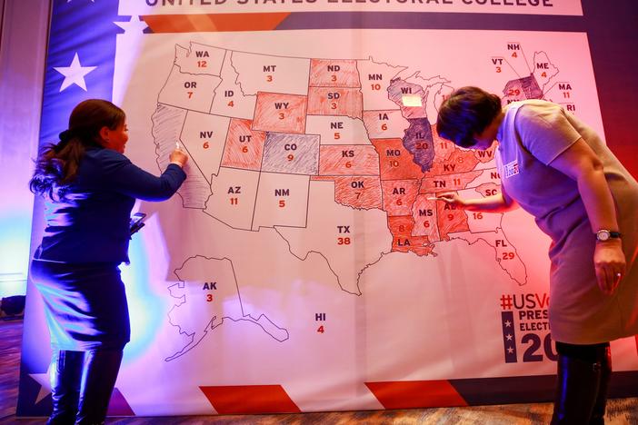 People color in a U.S. electoral map during a 2020 presidential election watch party at the U.S. Embassy in Ulaanbaatar, Mongolia.