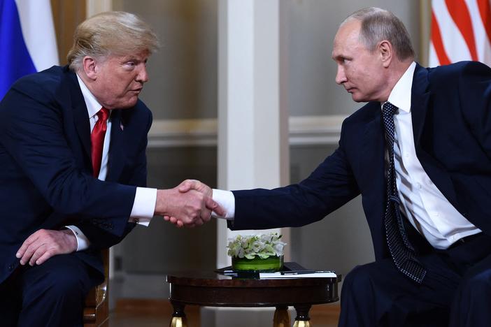 Russian President Vladimir Putin and then President Donald Trump shake hands before a meeting in Helsinki, on July 16, 2018. A new book by the journalist Bob Woodward reports that Trump secretly shared COVID-19 tests with Putin in 2020.
