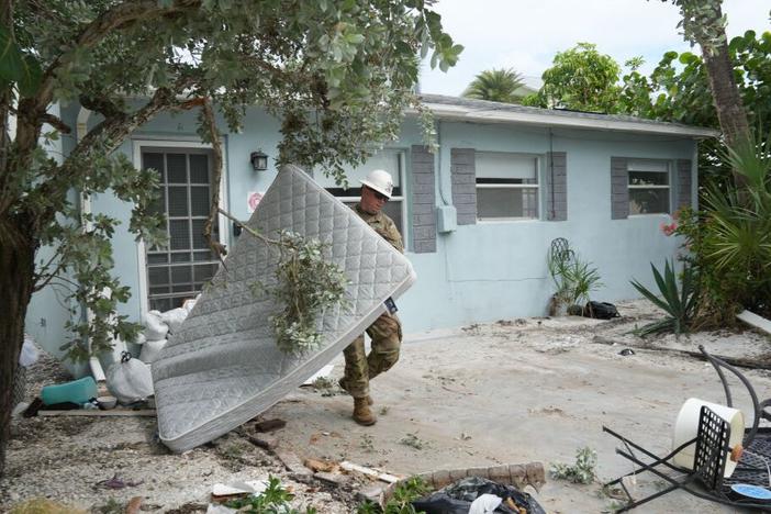 A Florida Army National Guard member works to remove debris in the Pass-A-Grille section of St. Petersburg on Monday, ahead of Hurricane Milton's expected landfall.