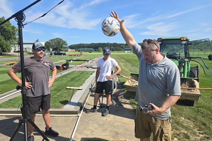 Michigan State University lead research associate Ryan Bearss and students drop soccer balls on several experimental patches of turf to determine whether their bounce meets regulation height.