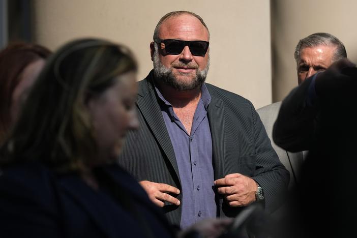 Right-wing conspiracy theorist Alex Jones stands outside the federal courthouse after a June bankruptcy hearing in Houston.