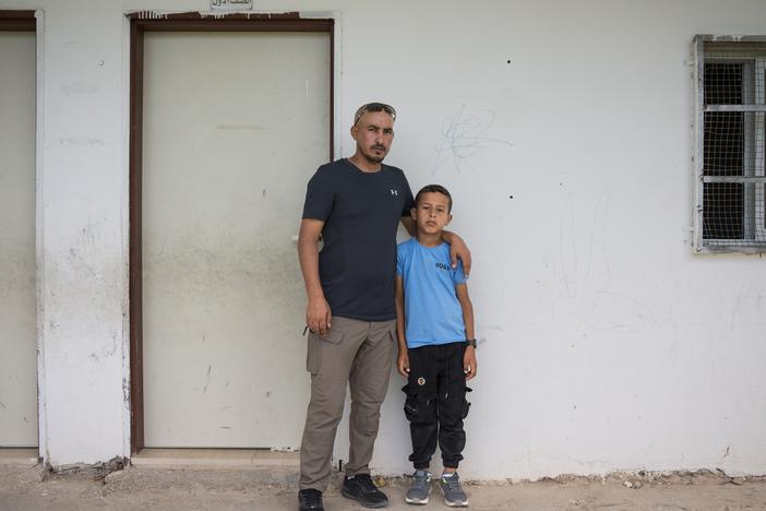 Suliman Mleihat, 32, and his nine-year-old son Obeida stand in front of Obeida's classroom, where he sheltered from settlers who attacked the school in the Mu’arrajat Bedouin community in mid-September.