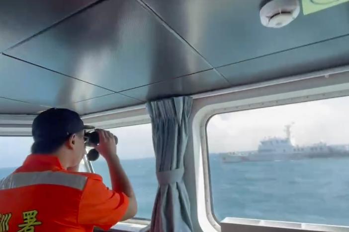 In this screen grab from video released by the Taiwan Coast Guard, a member of the Taiwan Coast Guard monitors a China Coast Guard boat as it passes near the coast of Matsu islands, Taiwan on Monday.