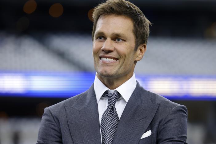 Fox Sports lead NFL analyst Tom Brady stands on the field before a game between the Detroit Lions and the Dallas Cowboys in Arlington, Texas, on Sunday. The former NFL star quarterback has purchased a minority stake in the Las Vegas Raiders.