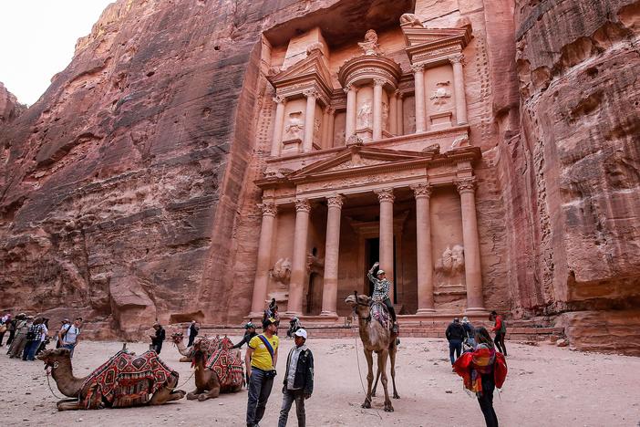 A tourist rides a camel at the Treasury site in Petra, Jordan, in December 2022. Archaeologists have discovered a hidden tomb at the site.