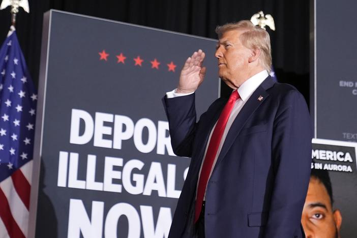 Republican presidential nominee Donald Trump salutes in Aurora, Colo., on Oct. 11. At that rally and others, he spoke of using a centuries-old act to expedite deportation of certain undocumented migrants.