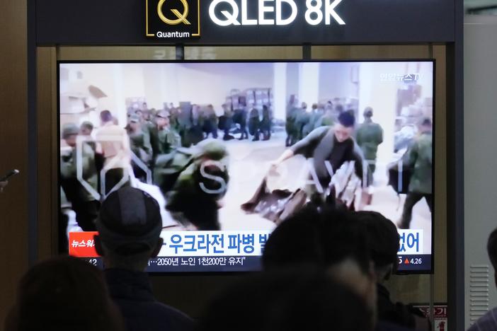 A TV screen shows an image of soldiers believed to be from North Korea stand in line to receive supplies from Russia during a news program at Seoul Railway Station in Seoul, South Korea, Monday, Oct. 21, 2024.