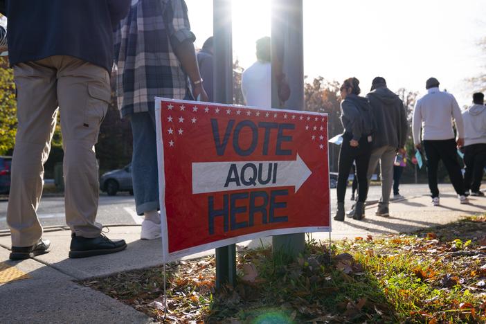 Voters line up outside of an early voting location for the 2022 midterm election in Woodbridge, Va.