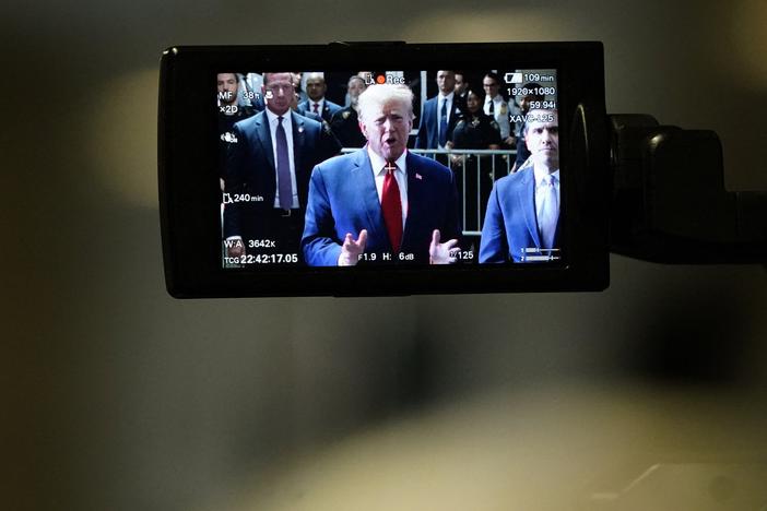 Former President Donald Trump, on a camera monitor, speaks to the press as he arrives at Manhattan Criminal Court on Feb. 15 for a hearing in his case of paying hush money to cover up extramarital affairs.