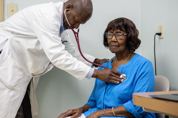 Morris Brown, a primary care physician, listens to Sarah McCutcheon’s heartbeat in the exam room at his medical office in Kingstree, South Carolina, which sits in a region that suffers from health care provider shortages and high rates of chronic diseases.