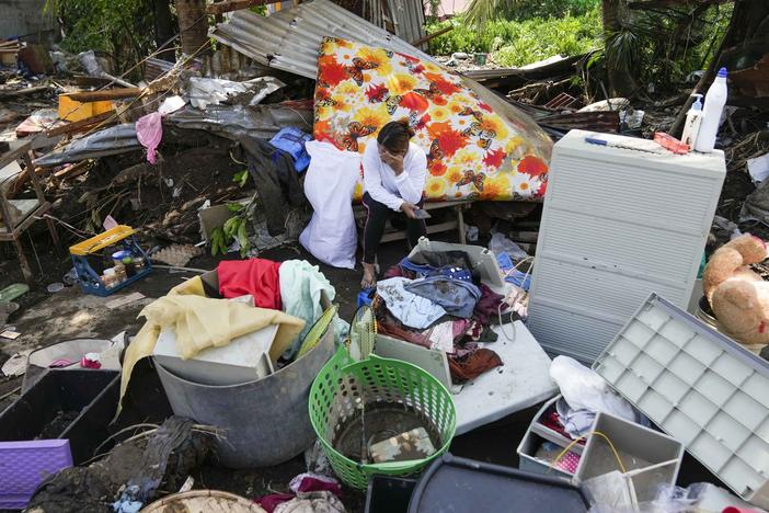 A resident sits beside belongings from their damaged home after a recent landslide triggered by Tropical Storm Trami struck Talisay, Batangas province, Philippines leaving thousands homeless and several villagers dead on Saturday, Oct. 26, 2024.
