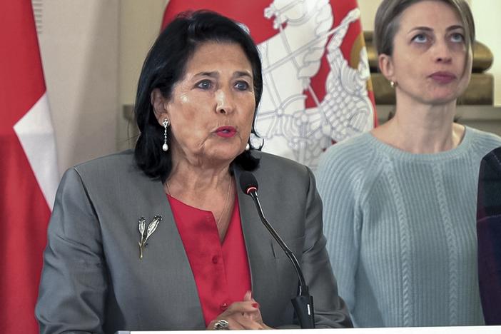 In this photo taken from video, Georgian President Salome Zourabichvili, left, speaks to the media as speaks to the media as and Nana Malashkhia, who leads the Coalition for Change parliament list, right, stands near, after the parliamentary election in Tbilisi, Georgia, on Sunday.