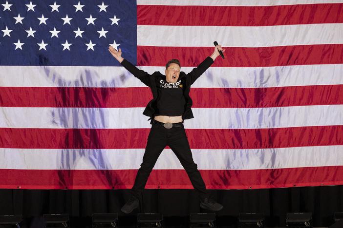 Elon Musk jumps onstage at a town hall event hosted by America PAC in support of Republican presidential candidate Donald Trump in Oaks, Pa., on Oct. 18.