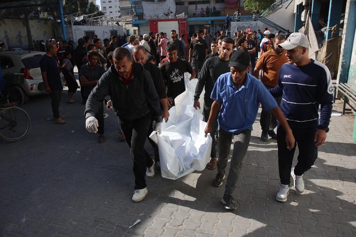 Residents and members of a civil defense team conduct search and rescue operations after the Israeli army targeted Asma School, run by the United Nations agency that aids Palestinians in the Shati refugee camp in Gaza Strip on Sunday. The wounded, including children, were brought to Shifa Hospital in Gaza City. The bodies of those who lost their lives were also brought to the hospital.