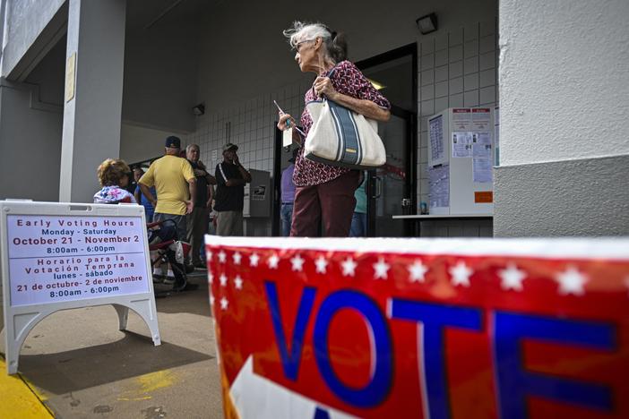 A person leaves an early voting site after casting a ballot on Oct. 21 in Deland, Fla. Florida is one of three states that recently sued the Biden administration over citizenship checks of voters.