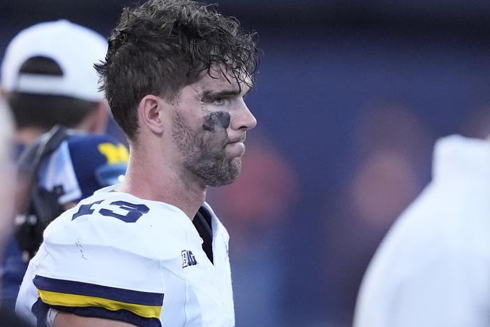Michigan quarterback Jack Tuttle stands on the sidelines in the closing minutes of the team's 21-7 loss to Illinois in an NCAA college football game Saturday, Oct. 19, 2024, in Champaign, Ill.
