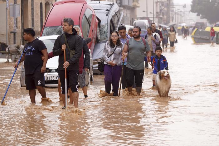 People walk through flooded streets in Valencia, Spain, on Wednesday.